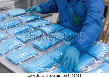 With the global spread of novel coronavirus pneumatia, medical mask production workers are organizing masks to prepare for the epidemic.COVID-19 outbreak Royalty-Free Stock Photo #1665409711