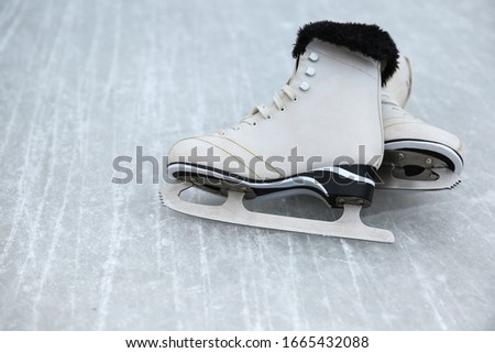 white ice skates are on the ice close up