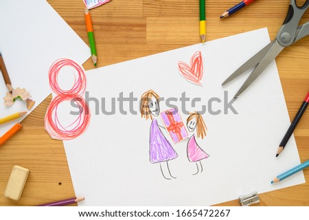 Background for Women's Day. Greeting card international women's day March 8.
Children's drawing, colored pencils lie on the table.
Number 8 cut from paper on background.
Cut from paper. creativity