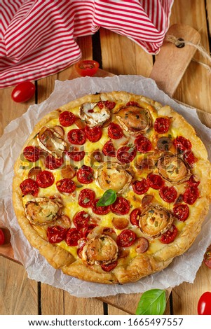 Savoury pastry tart quiche with cottage cheese, cherry tomatoes and goat cheese