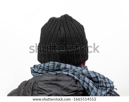 A middle-aged man turned from the back with his jacket,  scarf and cap