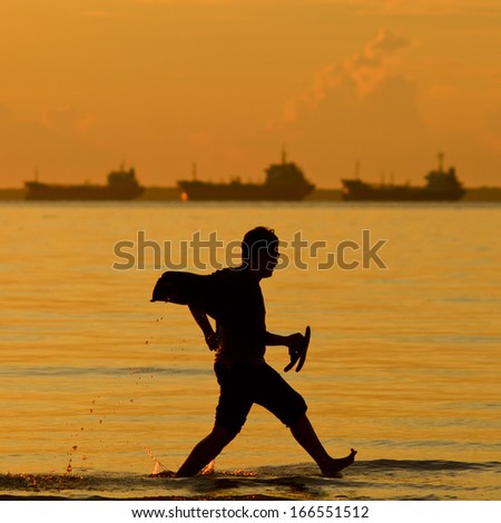 a silhouette of a man running during sunset