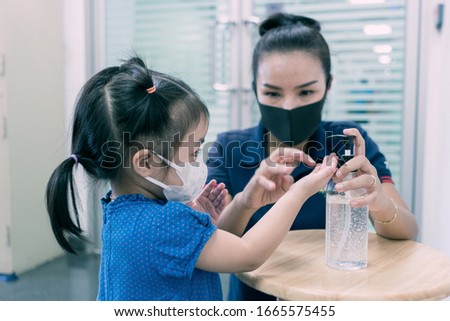 A mother and daughter using wash hand sanitizer gel pump dispenser, Washing hand with Alcohol Sanitizer, prevent the virus and bacterias, Hygiene and Covid-19 virus protection concept. Royalty-Free Stock Photo #1665575455