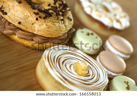 Cake "Paris-Brest", macaroons and lemon pies on a table