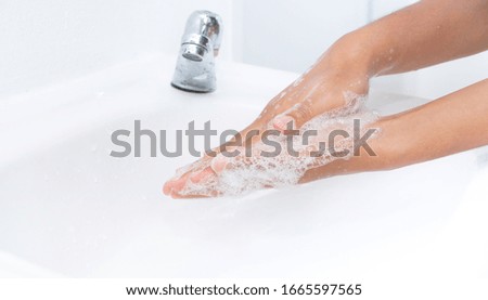 Hygiene concept. Washing hands with soap under the faucet with water
