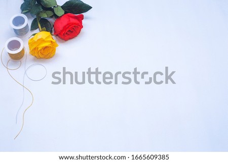 Multicolored roses and spool with space for design