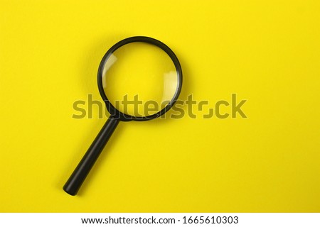 Magnifying glass on yellow background. Top view. Copyspace for your text Royalty-Free Stock Photo #1665610303