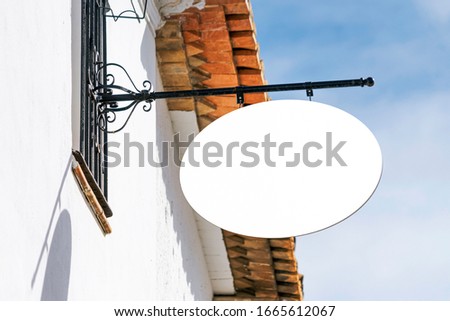 Blank white mock up of shop store restaurant vintage metal signboard on blue sky background
