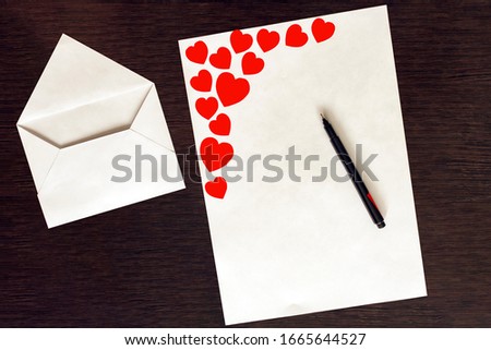 White empty envelope. An empty letter sheet with red hearts and a pen. Making a gift for an apology, Declaration of love, pleasant to your girlfriend, wife on Valentine's Day, wedding, birthday.