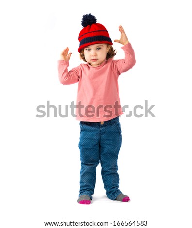 Little girl putting on a Christmas hat over white background 