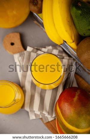 Fruit yellow juice on a table in a glass and decanter. Fruit basket. Vitamin nutrition. Healthy breakfast. Refreshing drink.