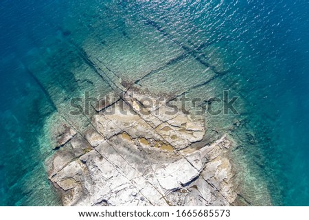an aerial view of the beach with flat rocky cliffs immersed in the sea, Duga Uvala, Istria, Croatia