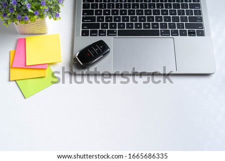 Business background concept idea in soft lighting with modern accessories, mock up notebook, small house plant, post it and car key on the office desk. 