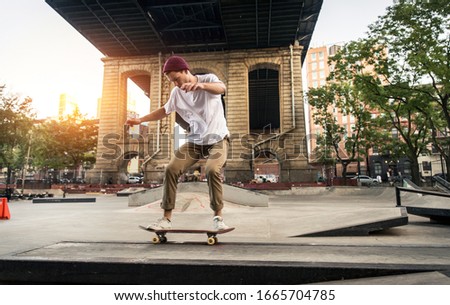 Young adult skating outdoors - Stylish skater boy training in a nNew York skate park, concepts about sport and ifestyle