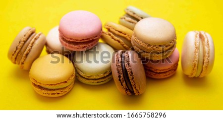 Colorful abstract background with traditional french macaroons cookies, over yellow banner.