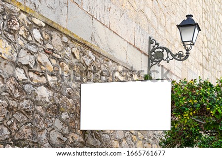 Mock up. White blank signboard advertising board, information board on old stone wall in european city