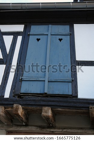        Romantic wooden blue heart window in France.                        