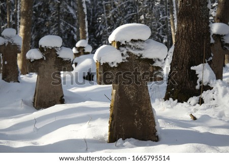 ancient tombstone crosses in winter in the cemetery