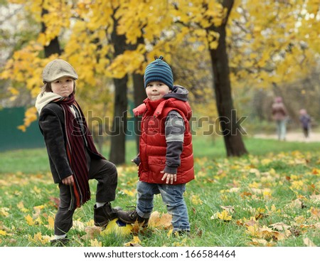 two boys with ball in the autumn park
