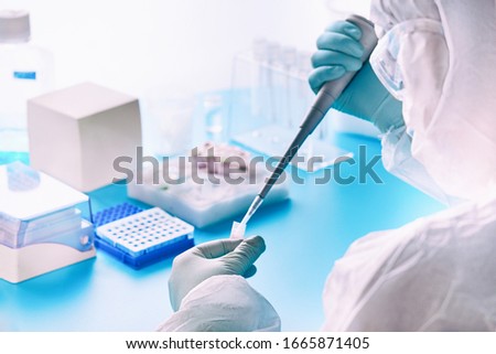 SARS-COV-2 pcr diagnostics kit. Epidemiologist in protective suit, mask and glasses works with patient swabs to detect specific region of 2019-nCoV virus causing Covid-19 viral pneumonia. Royalty-Free Stock Photo #1665871405