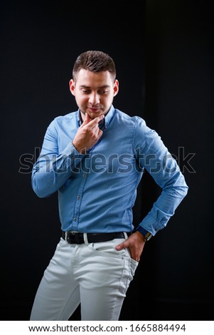 Fellow businessman in blue shirt and white trousers on a black background