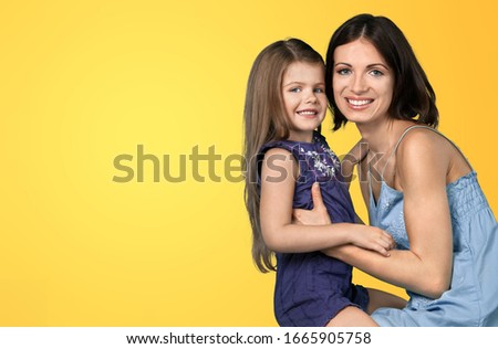 A young mother and a cute child daughter hugging