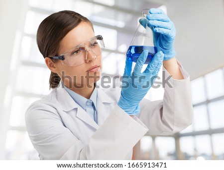 Scientist woman with liquid in a researcher test tube Royalty-Free Stock Photo #1665913471