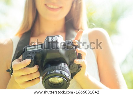 Woman photographer takes a picture with professional camera from touristic trip to asia