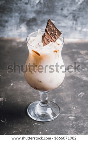 Creamy cocktail with ice and slice of chocolate. Selective focus. Shallow depth of field.