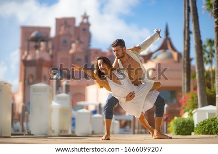 Young happy couple dancing in the summer park