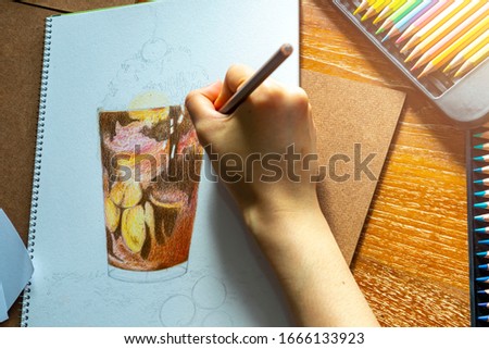 Hand drawing. Pencilcolor art. A hand holding pencilcolor coloring chocolate milkshake.