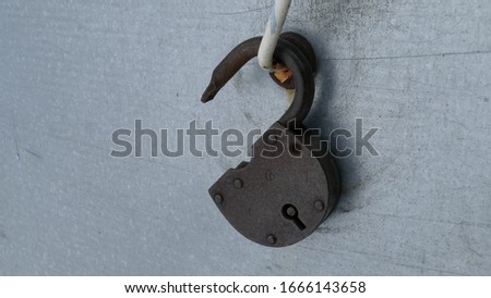 Old rusty door lock hanging on the door