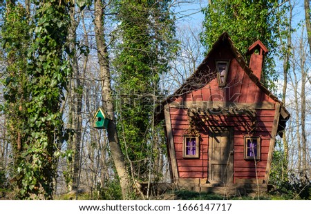 wooden fairy tale house among the flowers in the forest