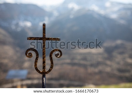 Iron cross in front of blurred Beautiful mountain. Beautiful mountain landscape.