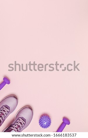 Sports equipment for women's training in pastel colored. Pink background, vertical picture.