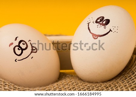 Two funny smiling  eastr eggs in a wooden basket