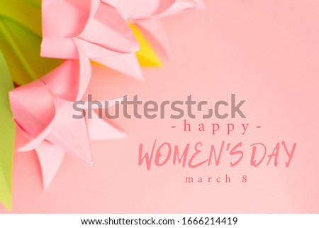 Happy Women's Day text on pink background with paper origami handmade tulips. March 8 greeting card. Holiday and gift concept