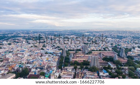 drone shot aerial view Madurai famous hindu temple sunset twilight beautiful weather bright sunny day towers cityscape busy town traffic mountains background ancient vintage place 
