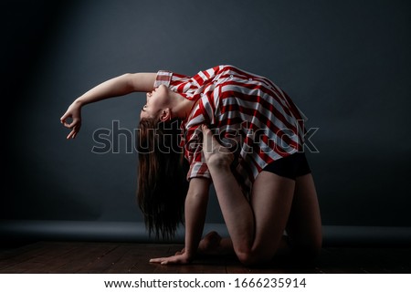Young woman yoga practicing yoga concept, doing one-legged exercises King Pigeon, Pada Rajakapotasana pose, working out, wearing casual clothes, looking smile camera, gray background loft pilatess