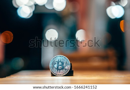 Silver bitcoin isolated on the table, glowing background