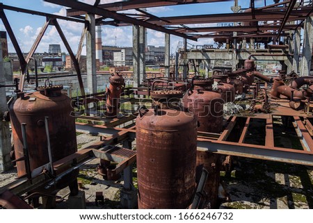 Abandoned ruined chemical plant with rusty tanks and pipes