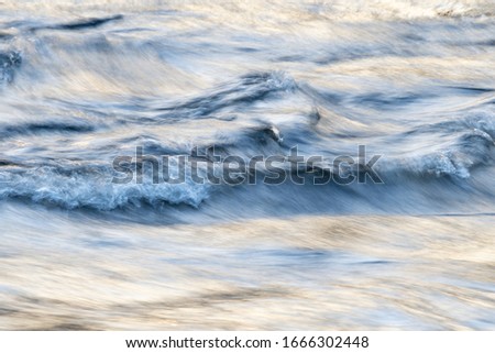 Abstract colorful picture of flowing water. Long shutter speed of a river. Paint with light.  smooth small waves, copy space, place for text.