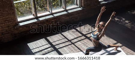 Top view young healthy sporty slim woman keep fit do practice hatha yoga instructor training Virabhadrasana I warrior 1 posture balance pose modern gym mat wooden floor concept copy space, banner Royalty-Free Stock Photo #1666311418