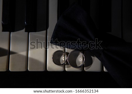  Wedding rings in piano. Light and rings.