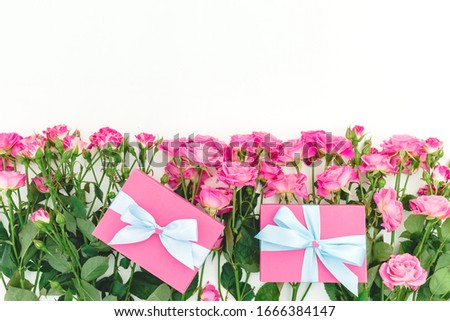Floral frame of roses flowers and gifts on white background. Flat lay, Top view. Happy birthday