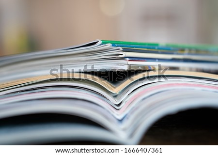 Closeup background of a pile of old magazines with bending pages