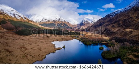 aerial drone footage of winter in glen etive and loch etive in the argyll region of the highlands of scotland showing clear bright white snow on the mountains of glencoe and the surrounding region