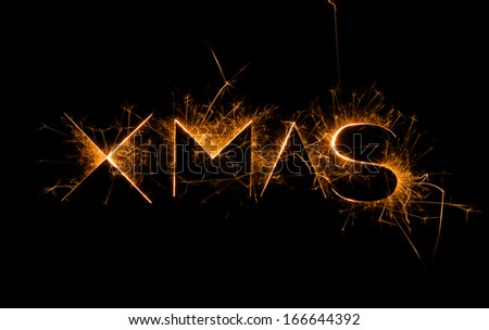 The word Xmas on a black background in sparkly bright effect with copy space.