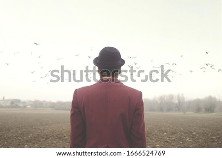 surreal calm man observing birds flying over his head, abstract concept Royalty-Free Stock Photo #1666524769