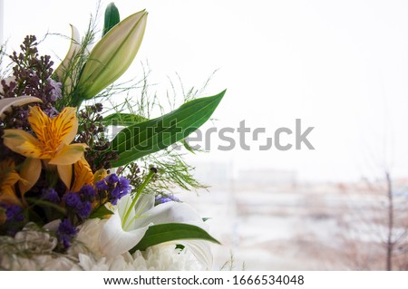 White lilyes, yellow and pink orchids, branch of lilac, chrysanthemums in the spring  tender bouquet on the background with window